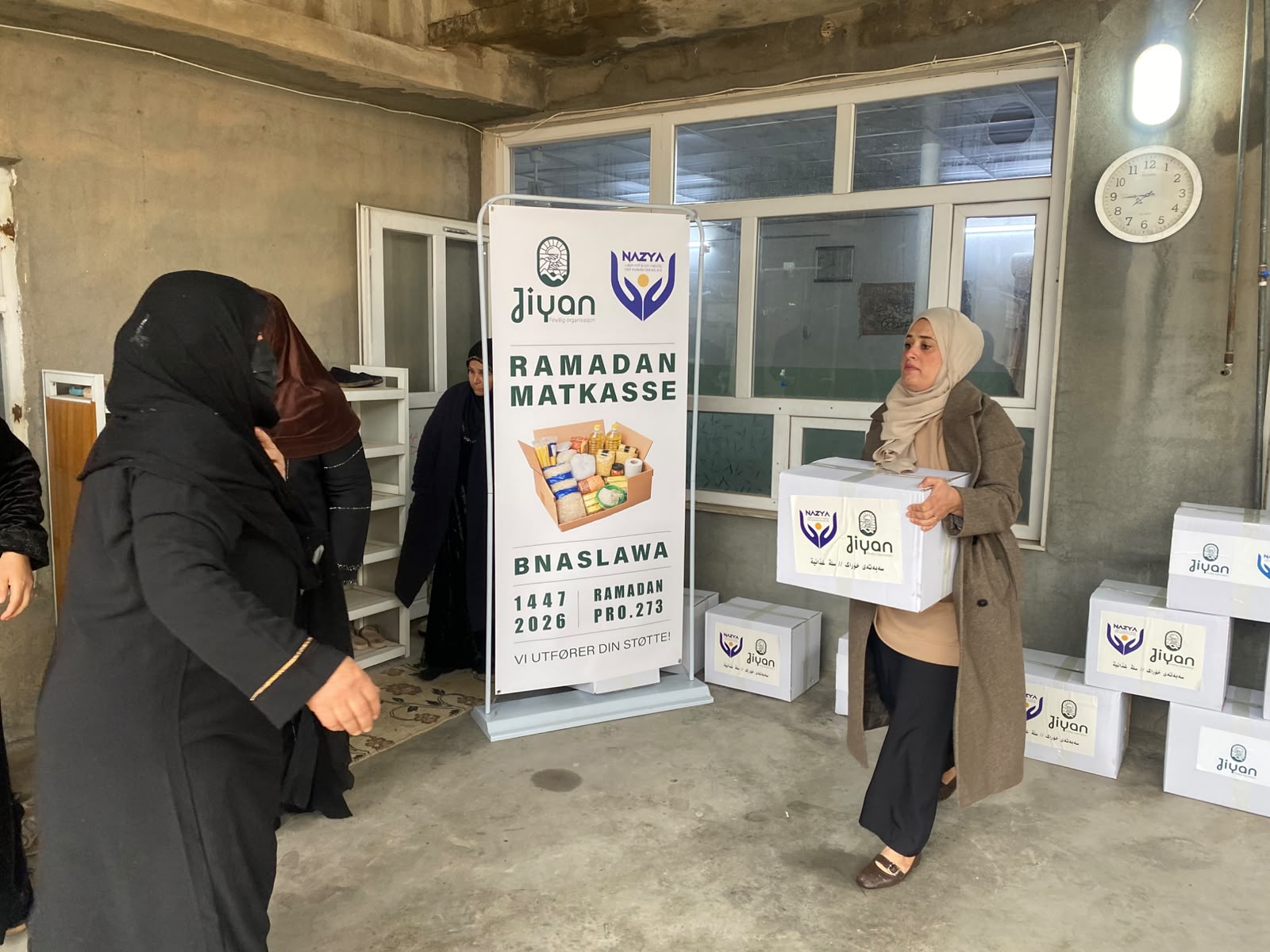 Nazya Organization distributing Ramadhan food baskets containing rice, oil, dates, and essential goods to families in Kurdistan