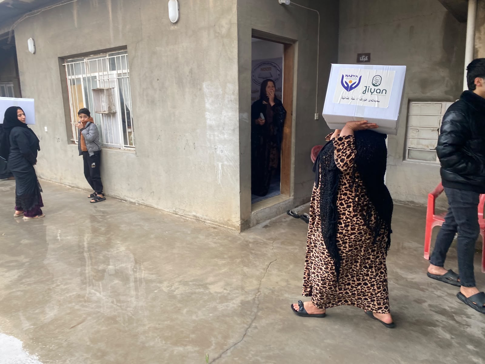 Nazya Organization distributing Ramadhan food baskets containing rice, oil, dates, and essential goods to families in Kurdistan